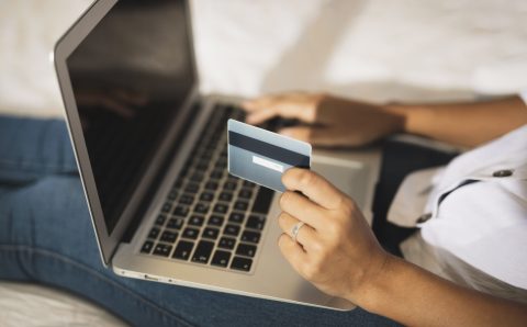 hands-holding-card-working-laptop